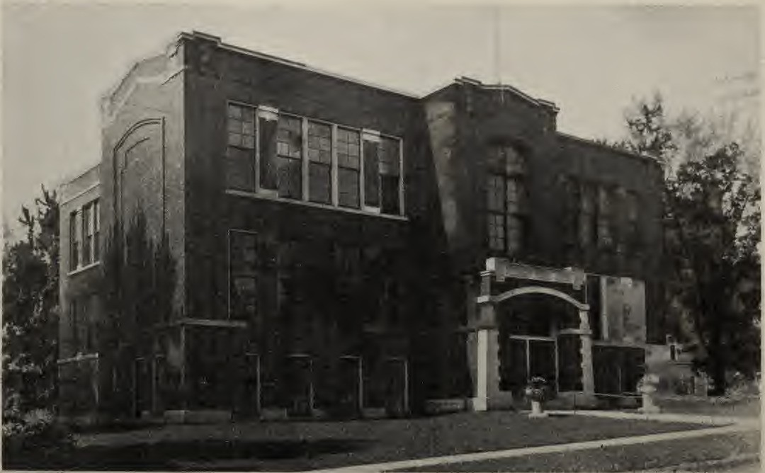 Historical photograph of Pleasant Street School, with brick walls and tall windows, published in 1915.